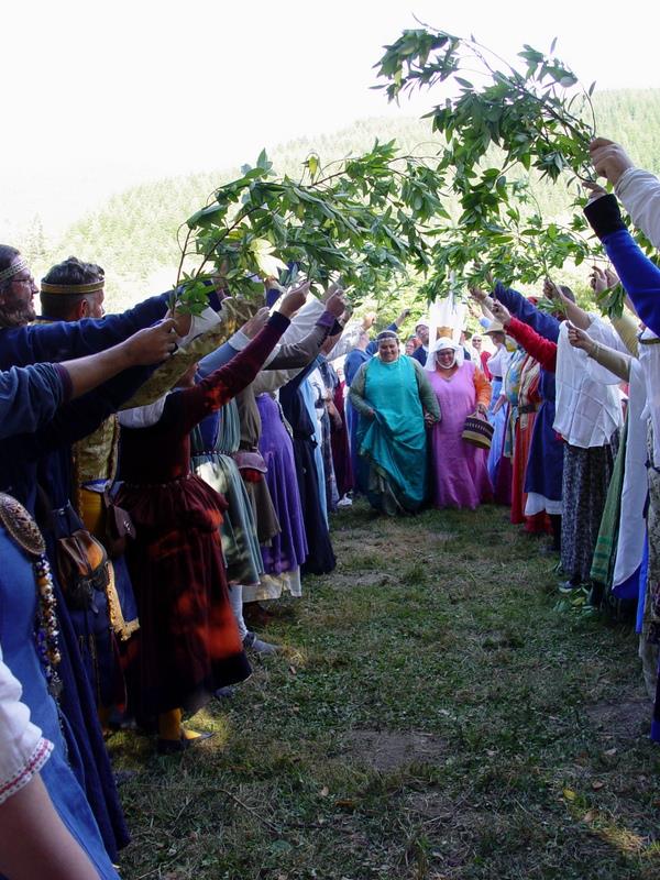Myself and my wife walking into SCA court, while the Order of the Laurel holds laurel branches over us in a tunnel.